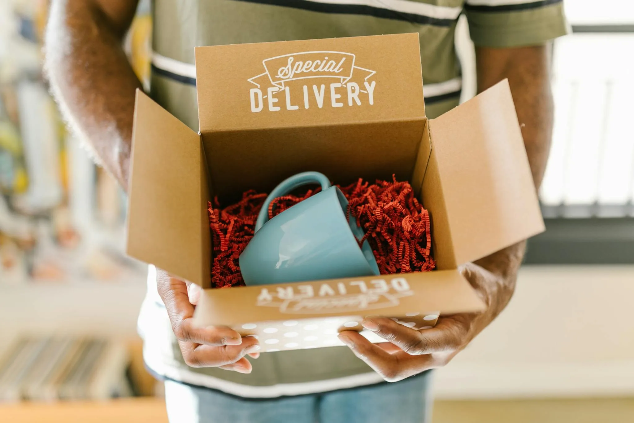 Bee Digital Marketing Agency Man holding a box with a special delivery coffee mug inside.