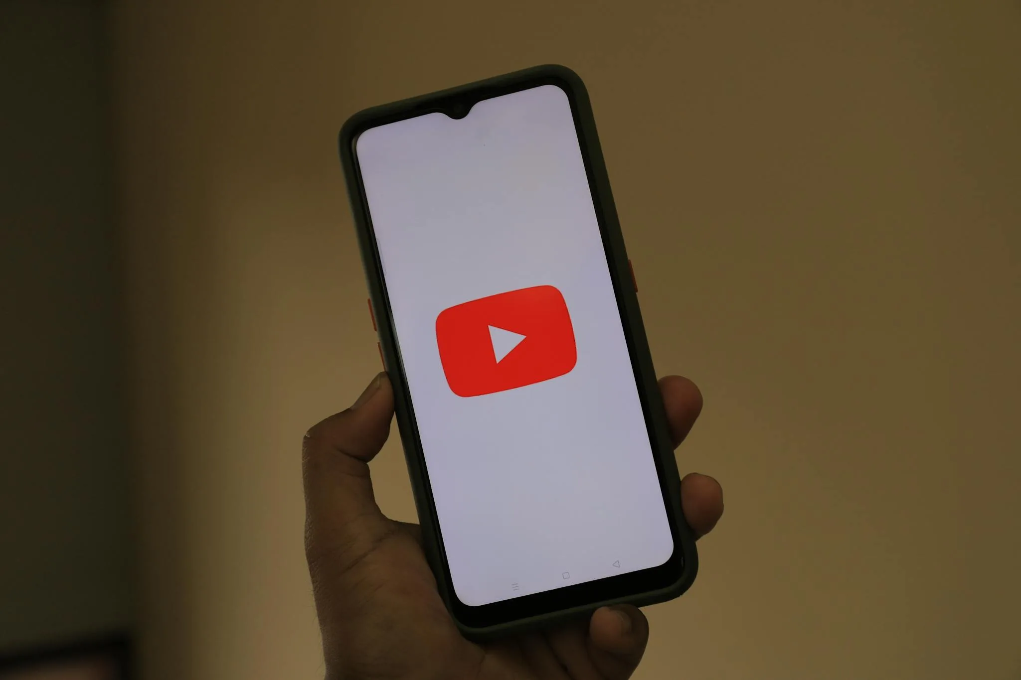 Bee Digital Marketing Agency Close-up of a smartphone displaying the YouTube app logo on the screen.